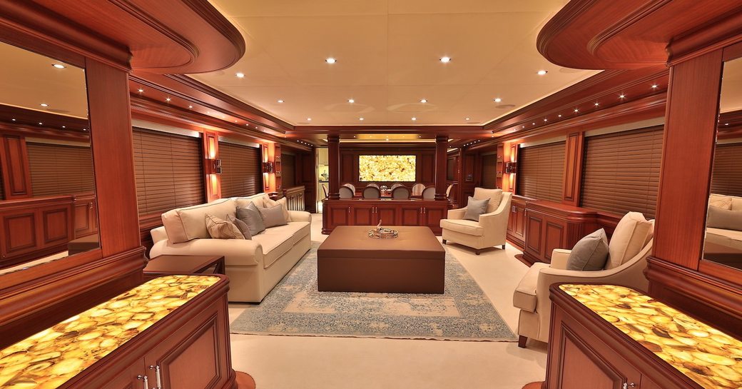 rich wooden wall panels and cream-coloured seating in the main salon of luxury yacht CLARITY 