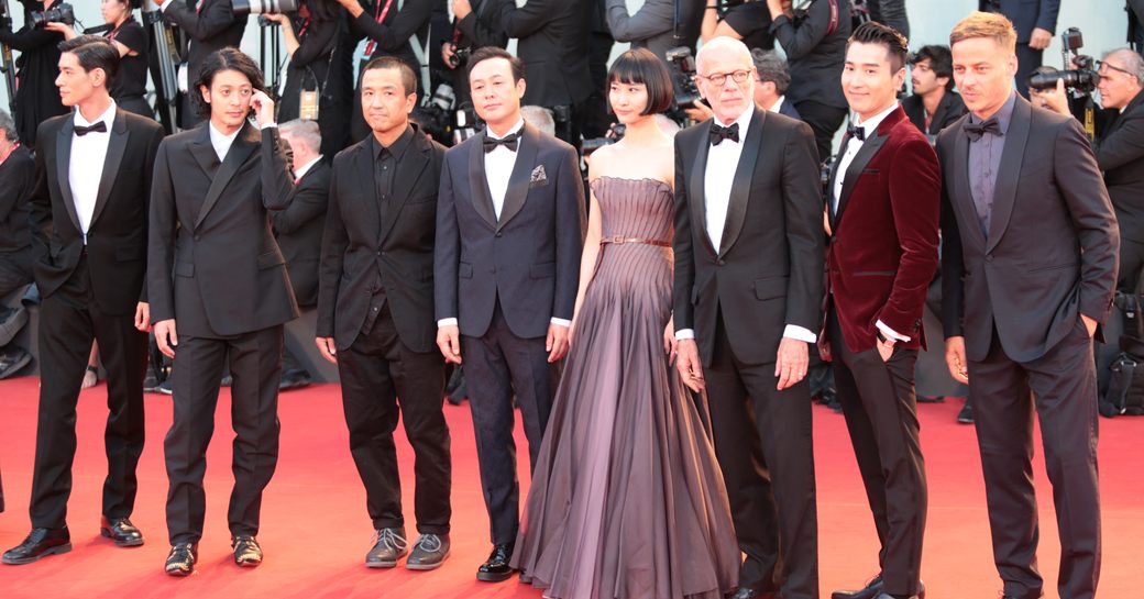 Film production team on red carpet at Cannes Film Festival. All lined up for photos.