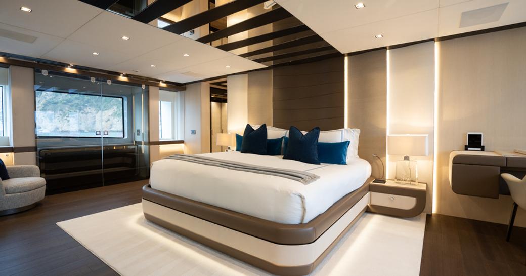 Master cabin onboard private yacht charter HALARA, central forward facing berth with wide windows in the background