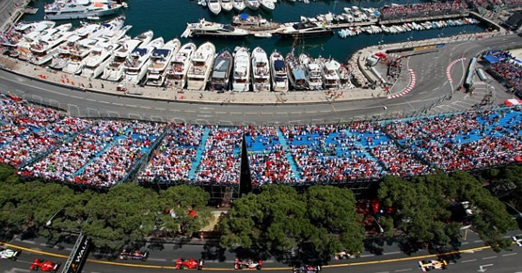 Historic Monaco Grand Prix in action with superyachts in harbour