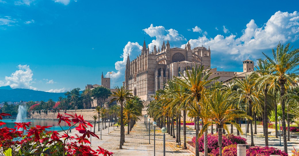 Mallorca palm-lined promenade with castle backdrop