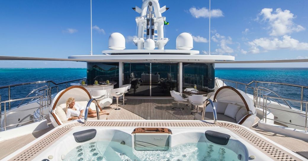 charter guest relaxes on the aft area of the wellness deck aboard motor yacht Grace E