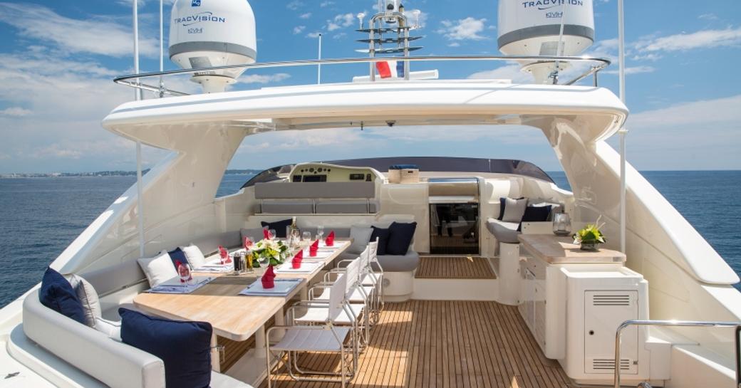 al fresco dining table and seating on the sundeck of superyacht Porthos Sans Abri 
