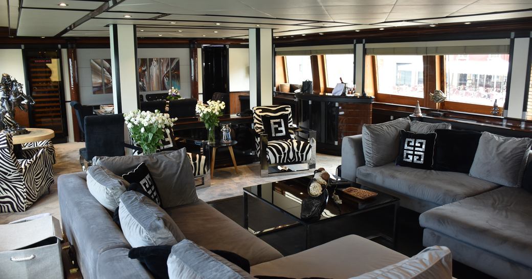 Overview of the main salon onboard charter yacht INDIGO STAR I, spacious lounge area surrounded by large windows