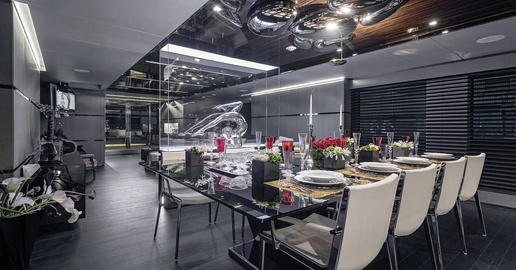 contemporary dining area and main salon on luxury yacht giraud, with steel chandelier above table