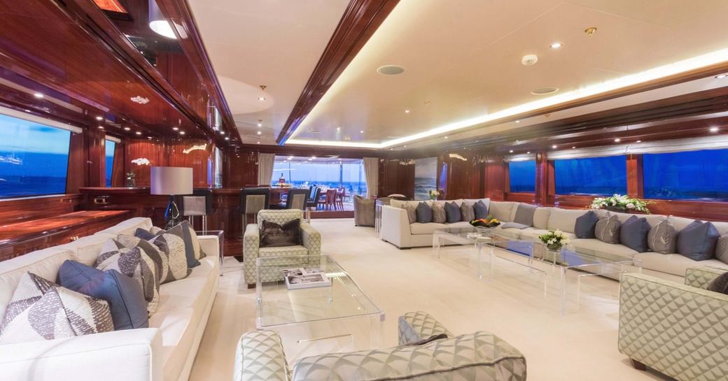Main salon onboard charter yacht JOIA THE CROWN JEWEL, spacious lounge area surrounded by large windows