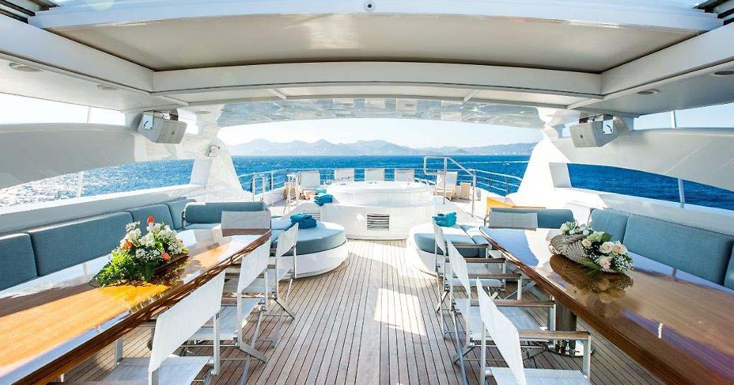 two tables and Jacuzzi on sundeck of motor yacht VICTORY