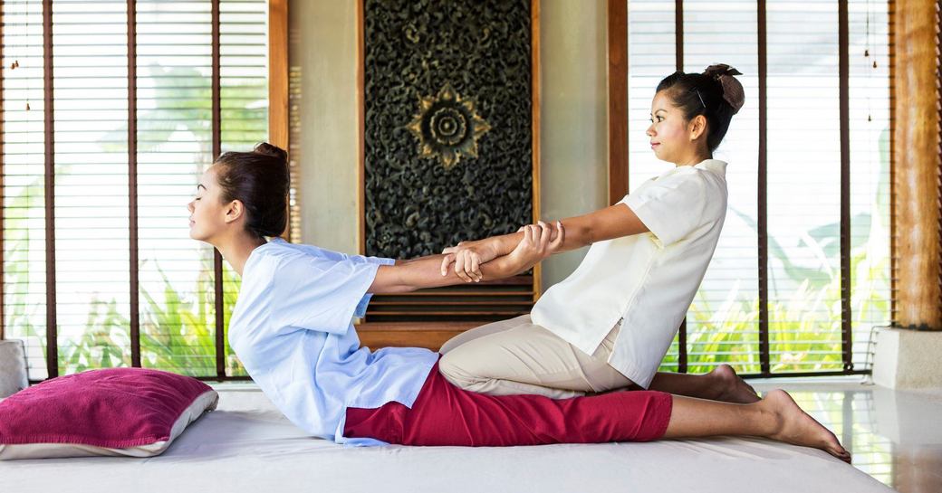 A young woman getting gently pulled in a traditional Thai massage in Phuket