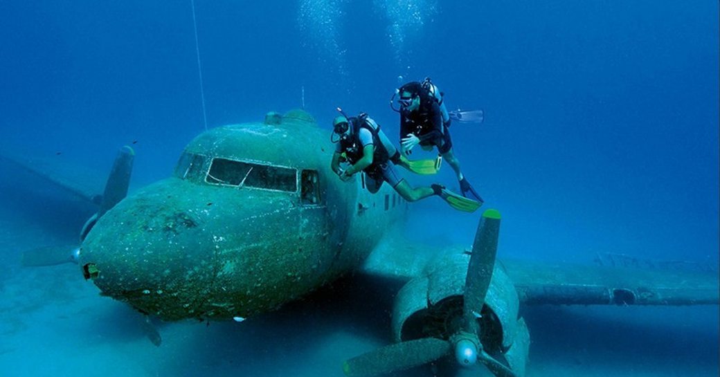 Two scuba divers check out a world war 2 plane wreck on the sea floor in Bodrum, Turkey