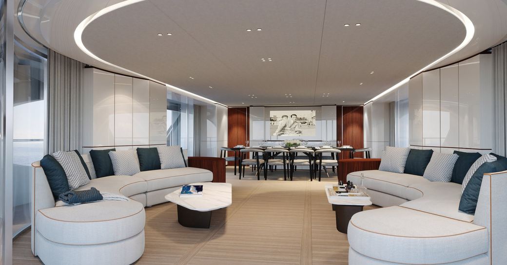 Main salon onboard charter yacht TOSUN, with white sofas in the foreground and a dining area aft