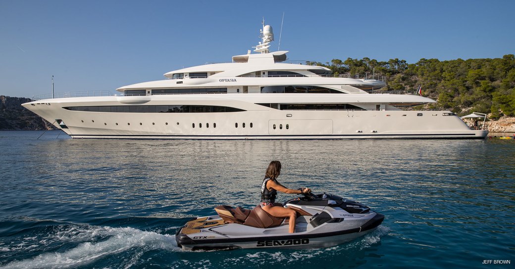 woman on jet ski in front of charter yacht o'ptasia