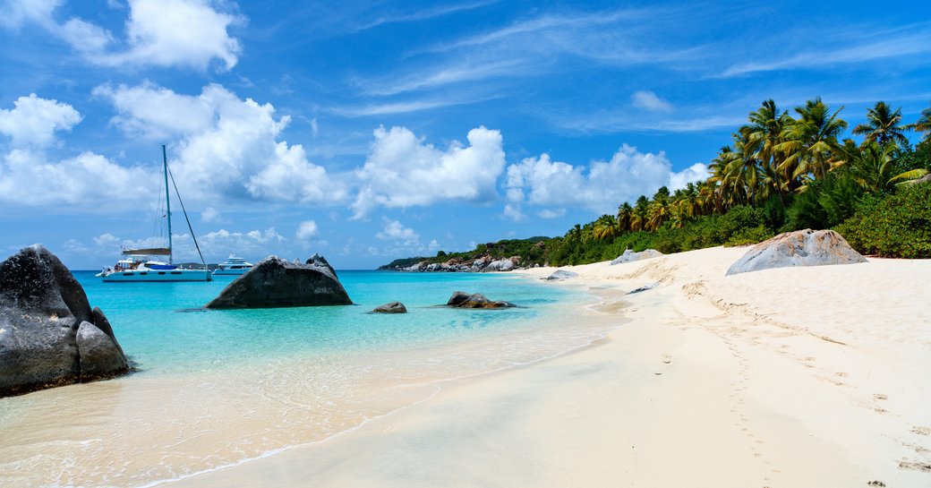 Virgin Gorda beach in Virgin Islands with white sand, blue sea and lush scenery
