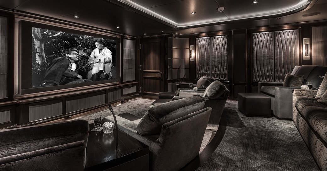 superyacht aquila cinema room with soft grey velvet chairs and matching carpet and glossy black ceiling