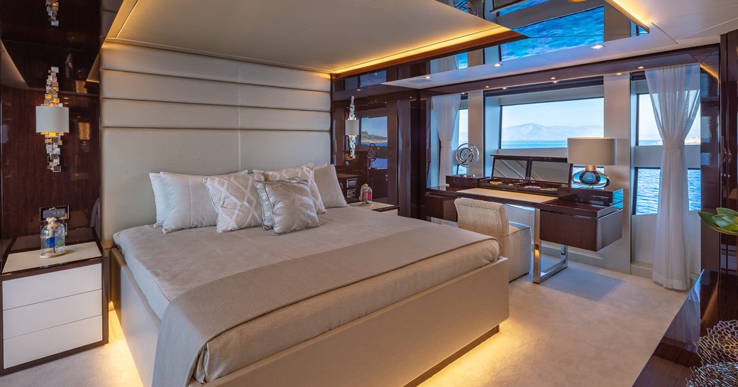 Master cabin onboard charter yacht AQUA LIBRA with central forward-facing berth and a dressing table underneath large windows