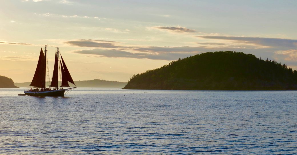 Sail yacht anchored in Maine bay at dusk