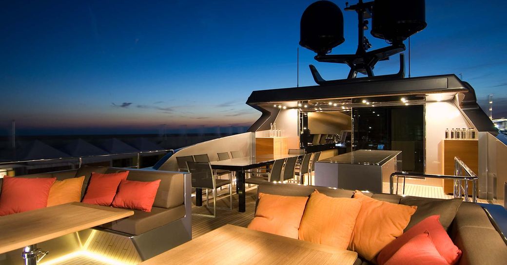 sundeck of luxury yacht 4A at night, with seating areas and alfresco dining