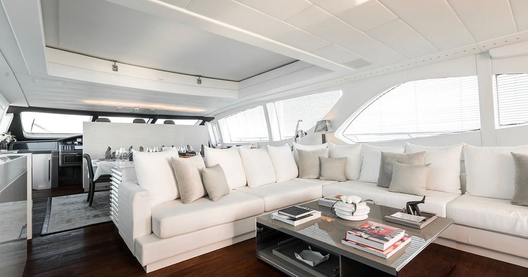 Main salon onboard charter yacht BEACHOUSE, corner sofa with wide windows in the background