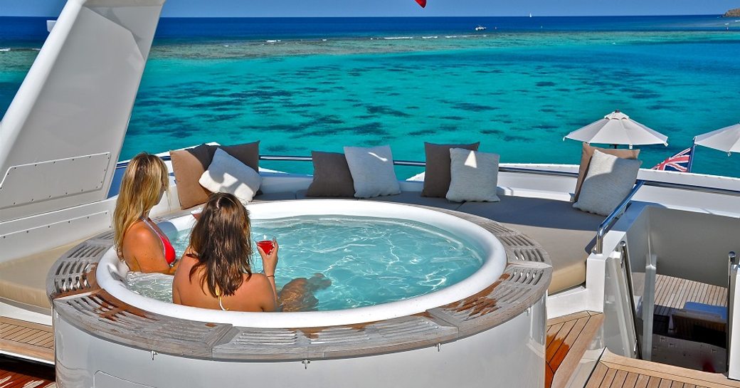guests relax in Jacuzzi on sundeck of charter yacht LIONSHARE 