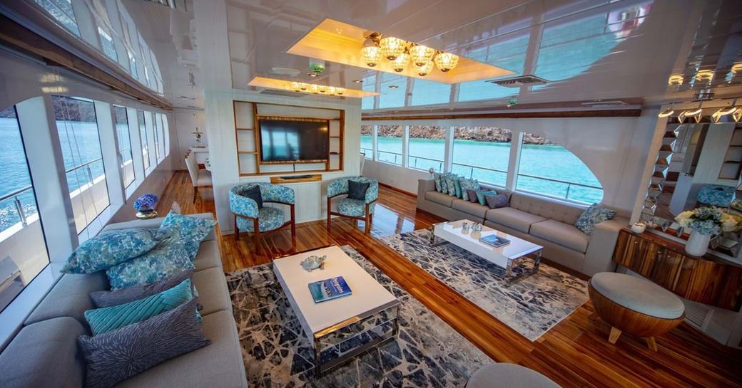 Light filled interiors of motor yacht Grand Daphne with sofas, tables and armchairs visible