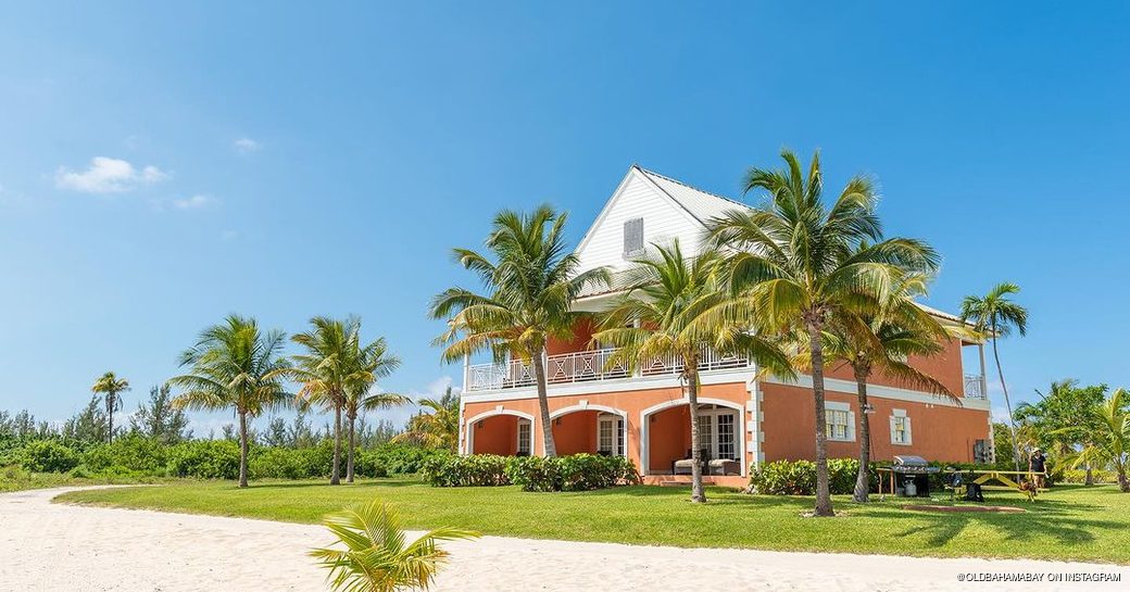 Orange and white house on the beachfront surrounded by palm trees