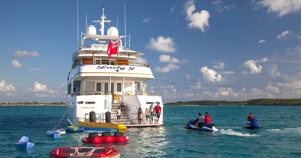 Superyacht Lady J surrounded by inflatable water toys and Jetskis