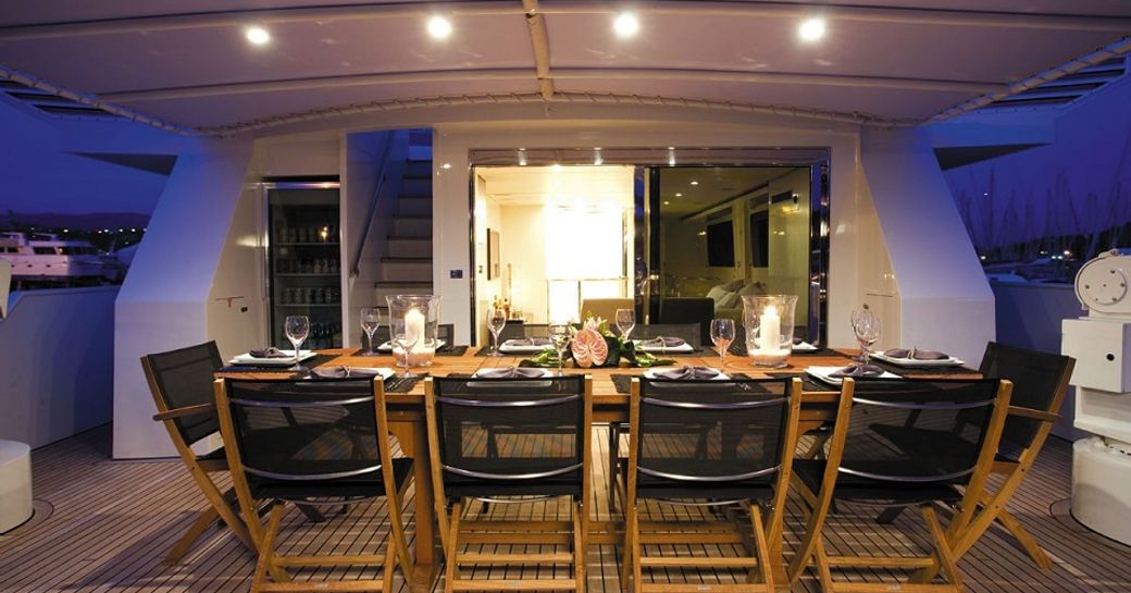 upper aft deck dining setup at night on board luxury yacht LIONSHARE 
