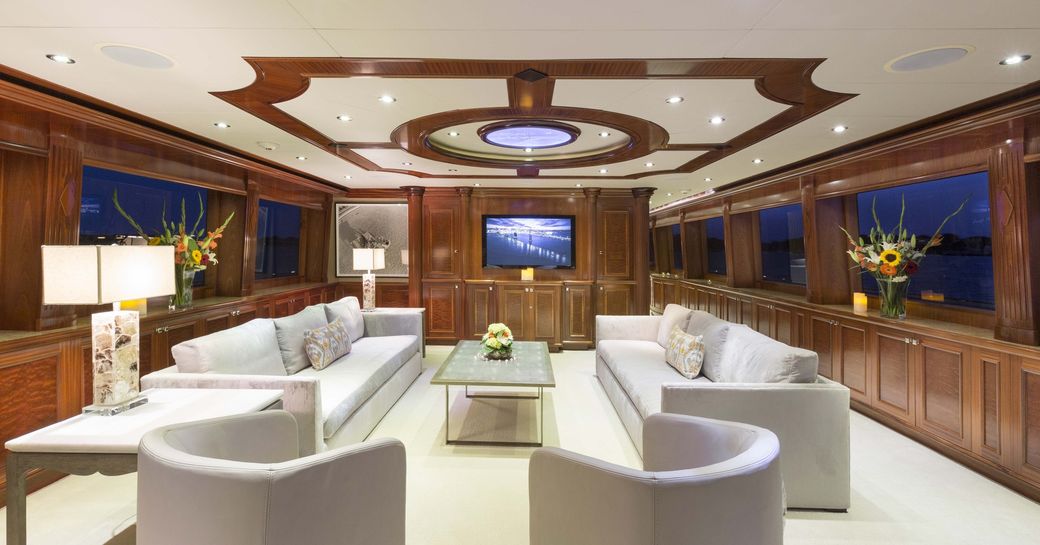 sofas and armchairs face a coffee table in the main salon aboard superyacht Far From It 