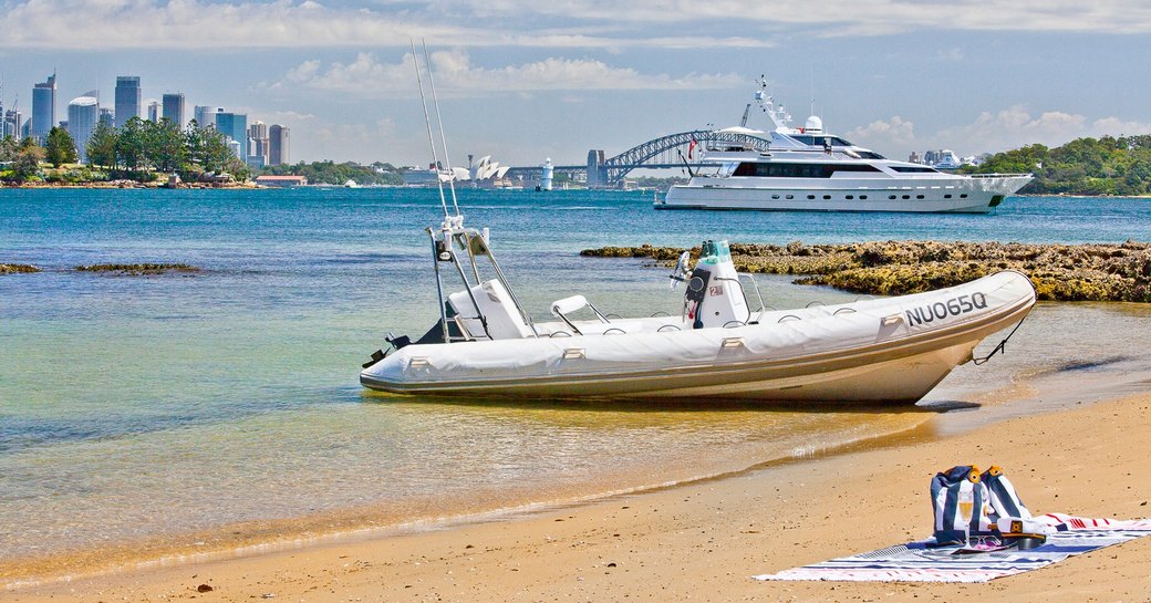 motor yacht Oscar II’ anchors in a quiet bay against the backdrop of Sydney's cityscape