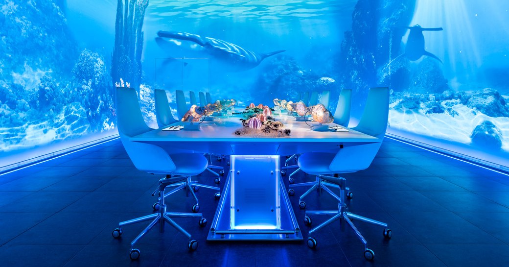 Table in Sublimotion, restaurant in Ibiza, with videos playing on the walls showing an underwater seascape