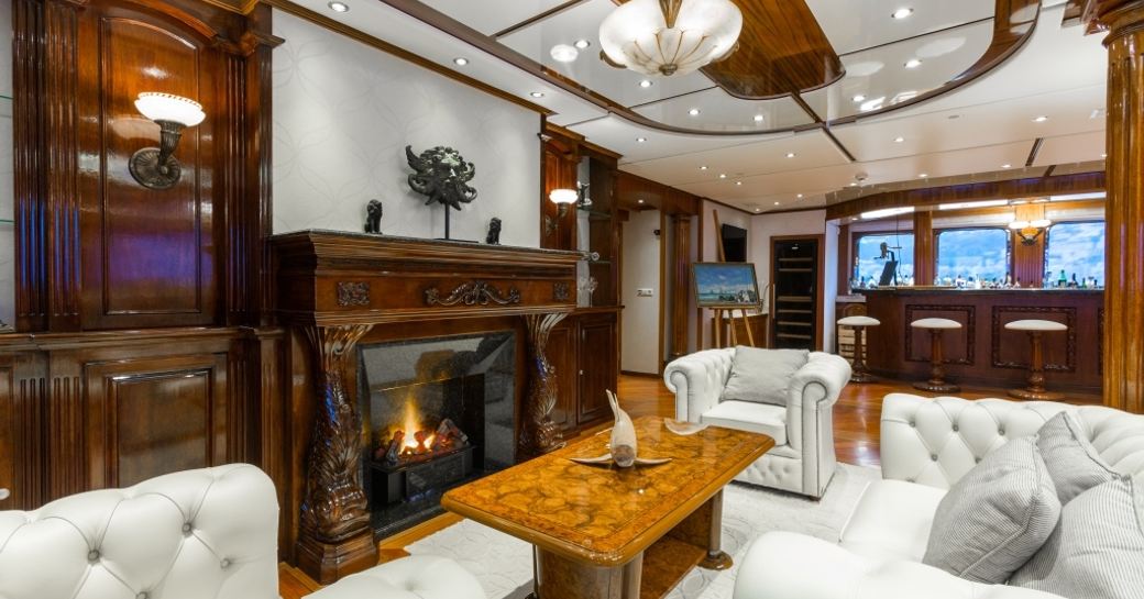 traditionally styled main salon with fireplace aboard superyacht LEGEND