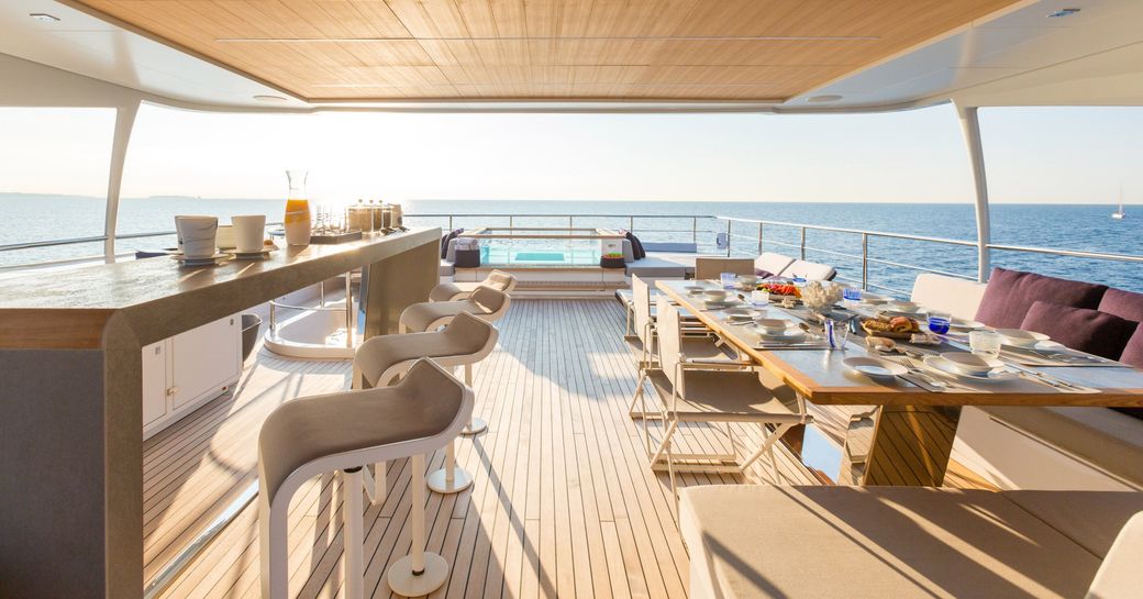 Sundeck on luxury yacht narvalo, with glass pool, beautiful bar and dining set-up