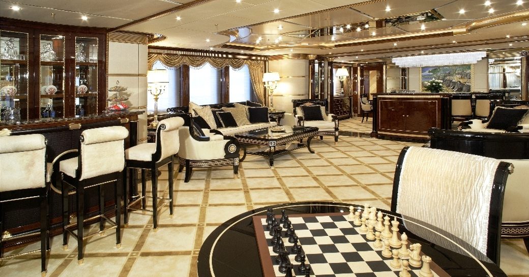 opulent main salon with bar, chess board and lounge areas aboard superyacht Mine Games 