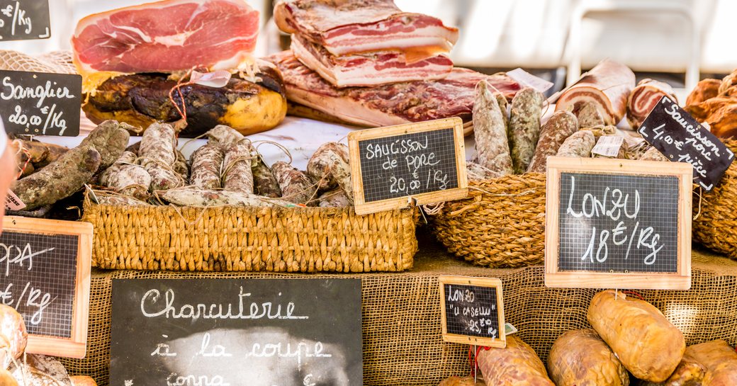 Fresh produce displayed with chalk labels in a Corsican market
