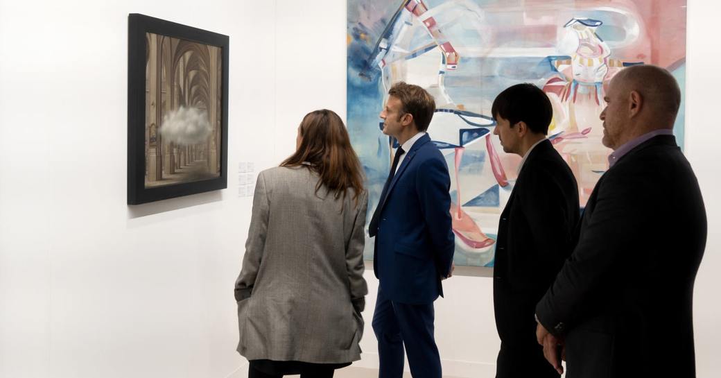 Emmanuel Macron, President of France, visiting Art Basel Miami, viewing a piece of art with colleagues.
