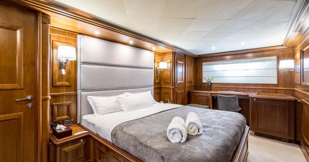 Guest cabin onboard charter yacht KLOBUK, central berth facing starboard with a wide window in the background