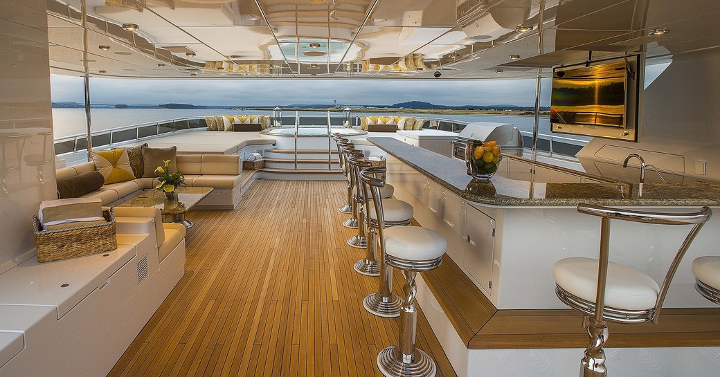 The sundeck of a superyacht with a bar running down the length of the right hand side of the photo