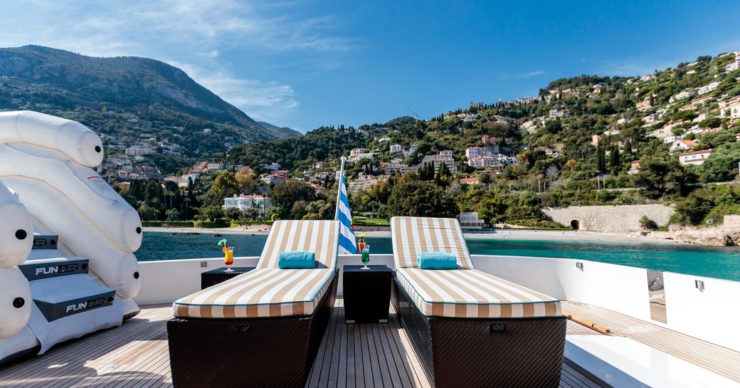 Sun loungers on sundeck of superyacht HEMILEA, with inflatable slide and views over the South of France coastline