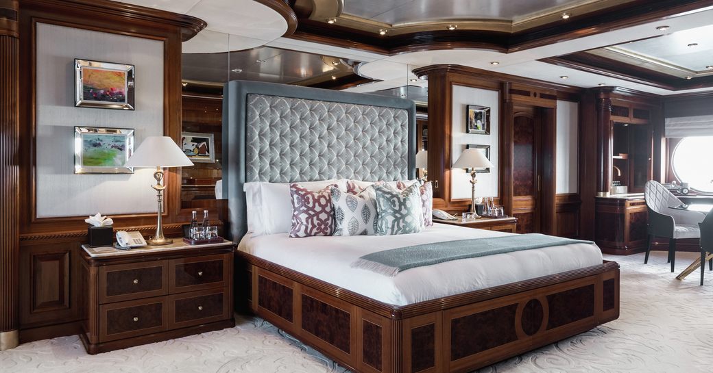 owner's cabin on charter yacht titania, with bed in centre and cherrywood surrounding 