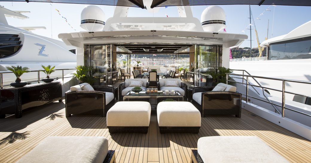 Overview of the sun deck onboard charter yacht ILLUSION V, sun loungers in the foreground with sky lounge visible in the background