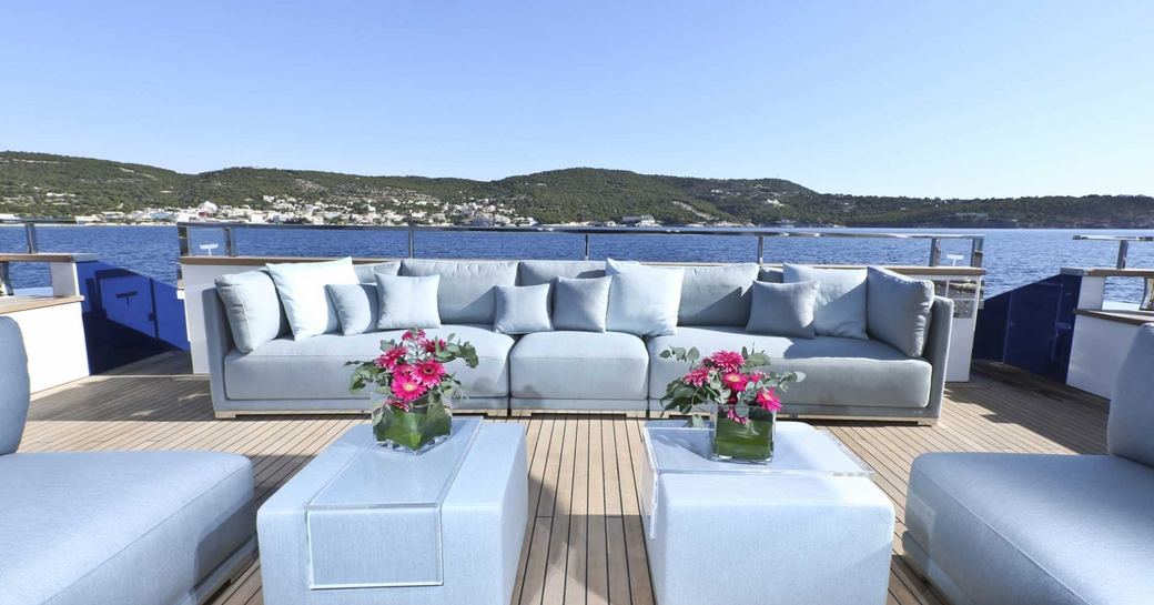 blue seating in alfresco lounge on sundeck of super yacht OURANOS