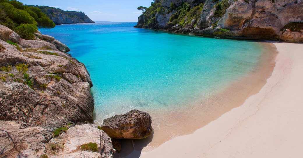 White sand beach in Ibiza, with turquoise water lapping the shore