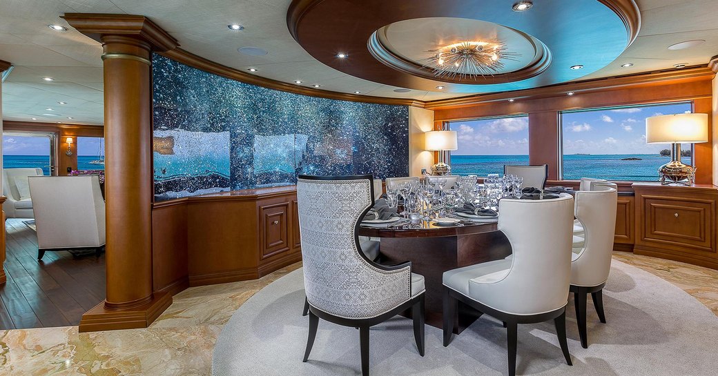 Formal dining area inside motor yacht M3, with sparkling glass partition 