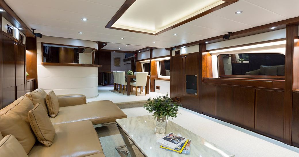 Main salon of charter yacht Mia Kai, with cream sofas and marble coffee table