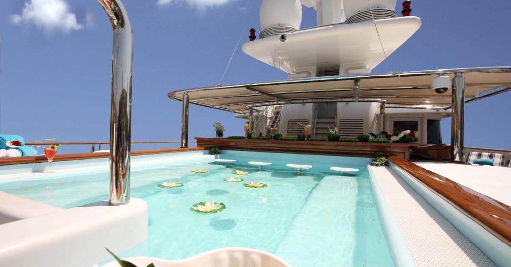Swimming pool onboard charter yacht NOMAD, with a swim up bar in the background