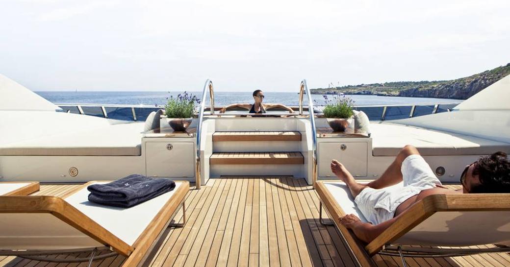Guest lounging in the Jacuzzi onboard charter yacht Knight