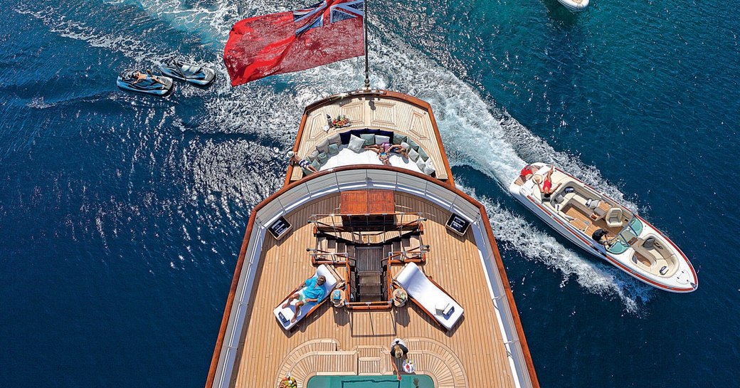 classic yacht talitha's sundeck loungers and pool as tenders race by