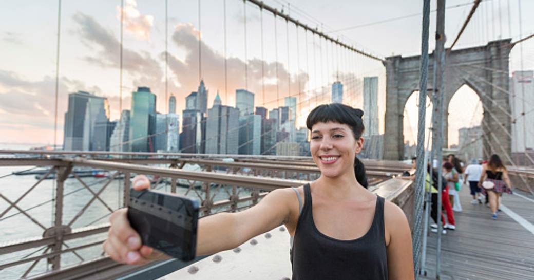 girl taking selfie on brookyln bridge in new york