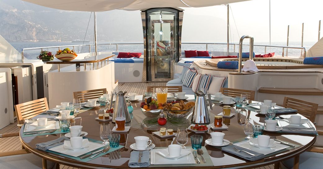 Sundeck with dining table and elevator in background on charter yacht LATITUDE