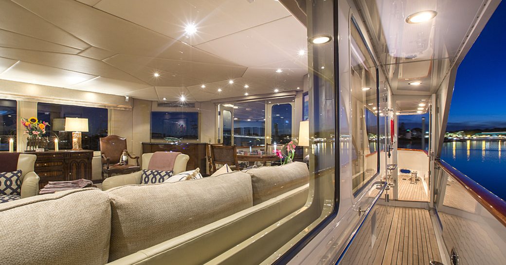 view of the main salon aboard motor yacht ‘Sweet Escape’ from her side deck at night