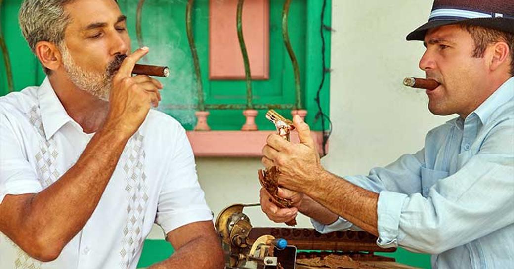 Two men enjoying smoking cigars in Cuba